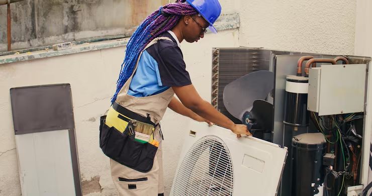 Technician fitting a new condenser fan cover
